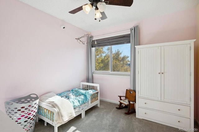 bedroom with ceiling fan, carpet, and a textured ceiling