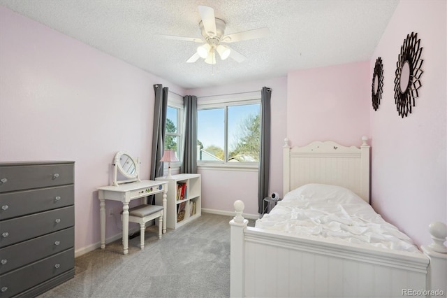 carpeted bedroom featuring ceiling fan and a textured ceiling