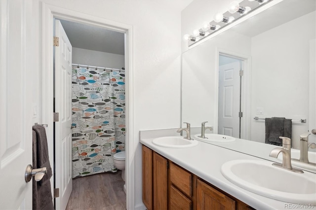 bathroom featuring a shower with shower curtain, vanity, toilet, and wood-type flooring