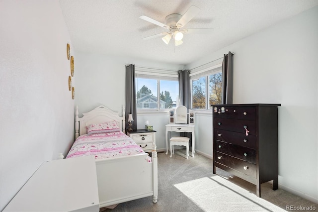 bedroom featuring light carpet, a textured ceiling, and ceiling fan