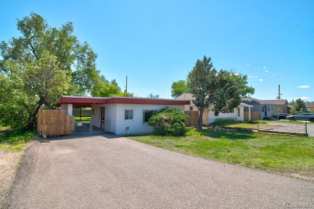 1560 Simms St, Lakewood, CO 80215 - ranch-style home featuring driveway, stucco siding, an attached carport, and a gate