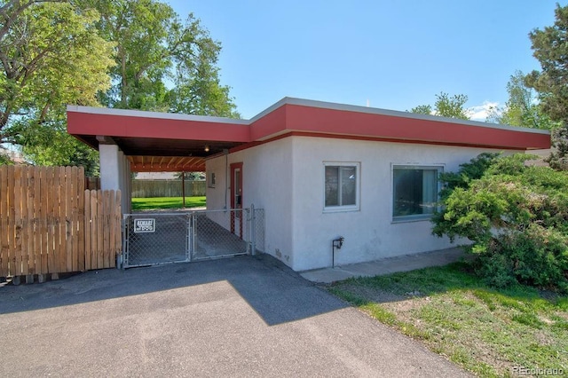 1560 Simms St, Lakewood, CO 80215 - view of property exterior featuring stucco siding, a gate, and driveway