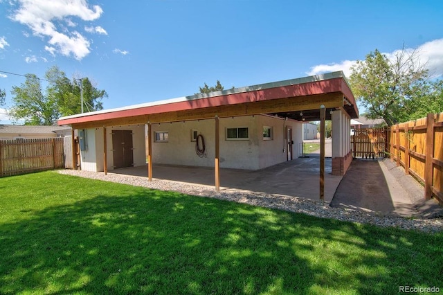 1560 Simms St, Lakewood, CO 80215 - rear view of house with an attached carport, stucco siding, and a patio area