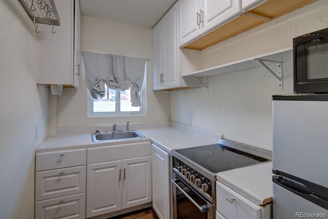 1560 Simms St, Lakewood, CO 80215 - kitchen with a sink, stainless steel range with electric cooktop, white cabinets, black microwave, and light countertops