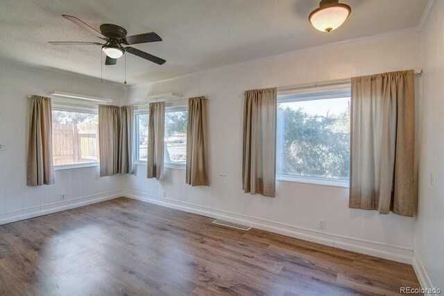 1560 Simms St, Lakewood, CO 80215 - spare room with wood finished floors, crown molding, ceiling fan, baseboards, and a textured ceiling