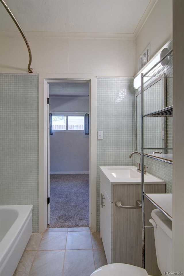 1560 Simms St, Lakewood, CO 80215 - full bath featuring tile patterned flooring, vanity, toilet, a bath, and ornamental molding