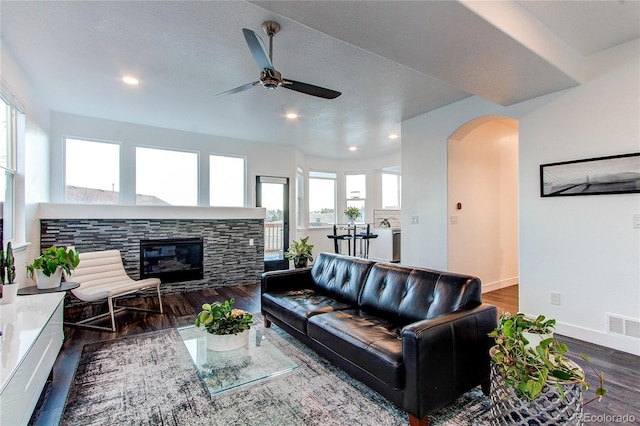 living room featuring a fireplace, ceiling fan, and dark hardwood / wood-style flooring