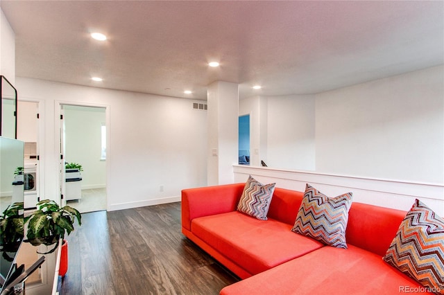 living room featuring washer / clothes dryer and dark wood-type flooring