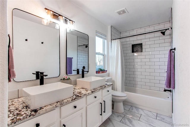 full bathroom with vanity, shower / bath combo, and toilet