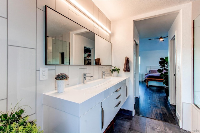 bathroom featuring decorative backsplash, hardwood / wood-style floors, a textured ceiling, and vanity