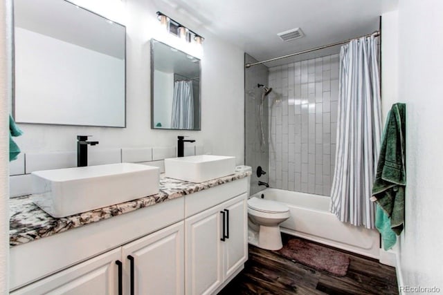 full bathroom featuring vanity, hardwood / wood-style flooring, toilet, and shower / bathtub combination with curtain