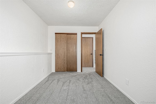 551 Snowy Owl Pl, Highlands Ranch, CO 80126 - unfurnished bedroom with a textured ceiling, carpet floors, a textured wall, and a closet
