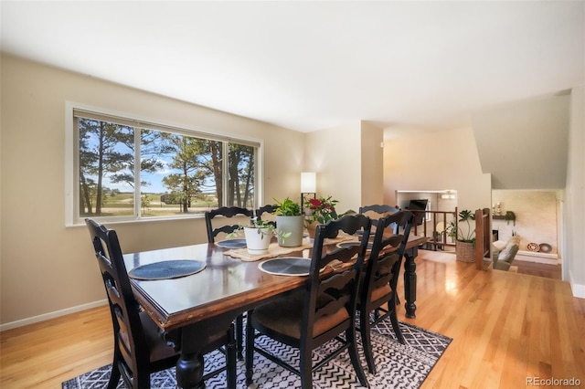 dining space featuring light wood-style floors and baseboards