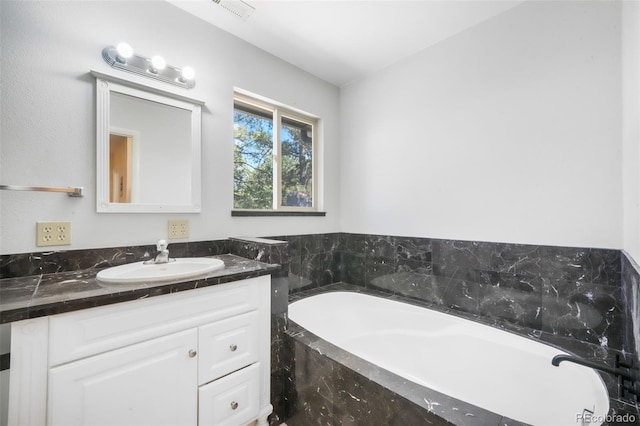 full bath with vanity and a garden tub