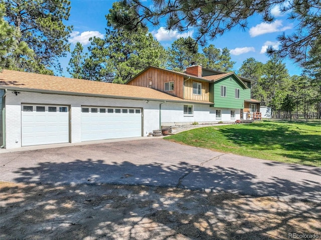 view of side of property featuring a garage, asphalt driveway, and a chimney