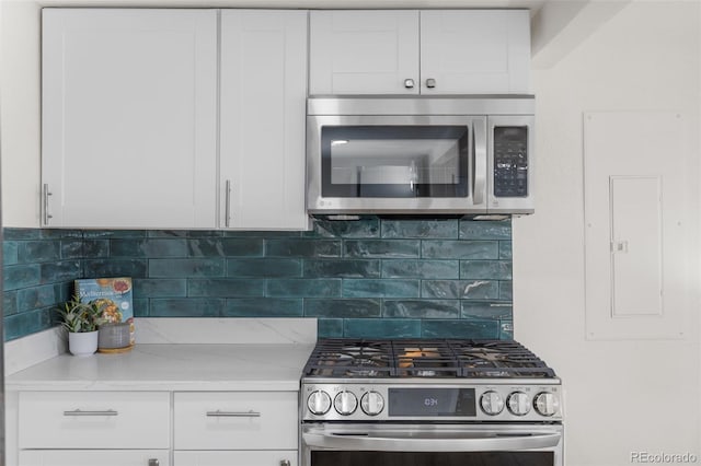 1130 Orchard St, Golden, CO 80401 - kitchen featuring appliances with stainless steel finishes, white cabinetry, and tasteful backsplash
