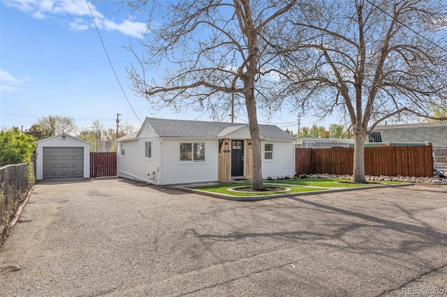 1130 Orchard St, Golden, CO 80401 - ranch-style house with driveway, fence, an outdoor structure, a detached garage, and a shingled roof