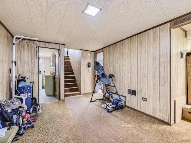 workout room featuring washing machine and dryer, a textured ceiling, and wooden walls