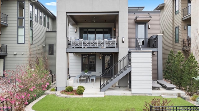 10113 Bellwether Ln, Lone Tree, CO 80124 - rear view of property featuring stucco siding, a patio area, stairway, and a balcony