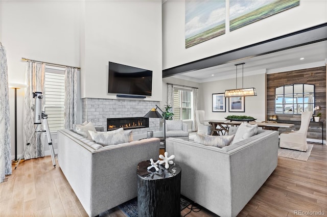 10113 Bellwether Ln, Lone Tree, CO 80124 - living area with crown molding, a high ceiling, a brick fireplace, and wood finished floors