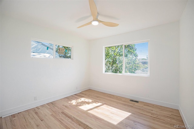 spare room with light wood-style floors, baseboards, and a ceiling fan