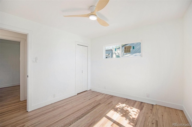unfurnished bedroom with light wood-type flooring, baseboards, a closet, and a ceiling fan