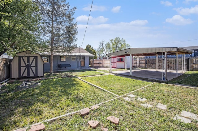 view of yard with a shed, an outdoor structure, a detached carport, and a patio area