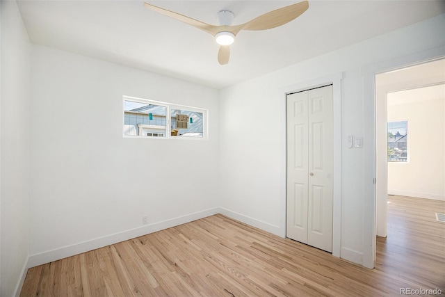 unfurnished bedroom with light wood-type flooring, baseboards, a closet, and ceiling fan
