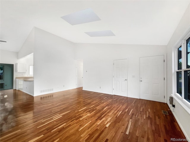 12375 Ivy Pl, Brighton, CO 80602 - unfurnished living room featuring wood finished floors, a skylight, and high vaulted ceiling