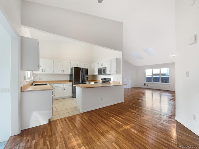 12375 Ivy Pl, Brighton, CO 80602 - kitchen featuring range, freestanding refrigerator, open floor plan, light wood-style floors, and stainless steel microwave
