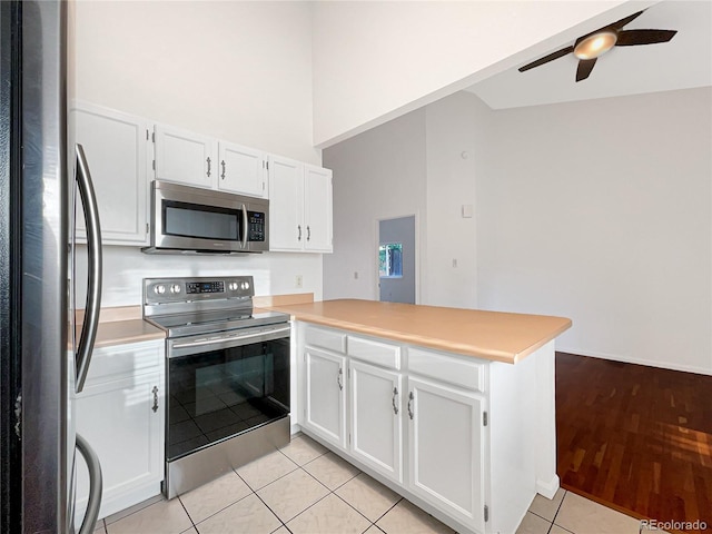 12375 Ivy Pl, Brighton, CO 80602 - kitchen with stainless steel appliances, a peninsula, ceiling fan, white cabinetry, and light tile patterned floors