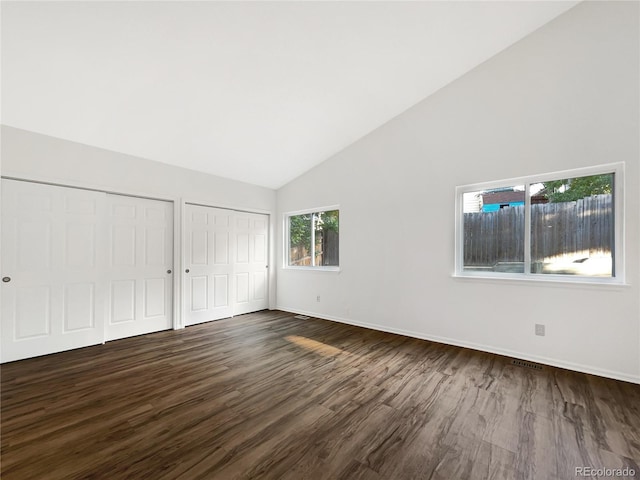 12375 Ivy Pl, Brighton, CO 80602 - unfurnished bedroom featuring two closets, dark wood-style floors, and high vaulted ceiling