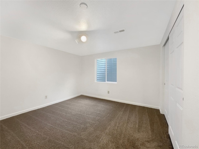 12375 Ivy Pl, Brighton, CO 80602 - unfurnished bedroom featuring dark carpet, a closet, and a textured ceiling