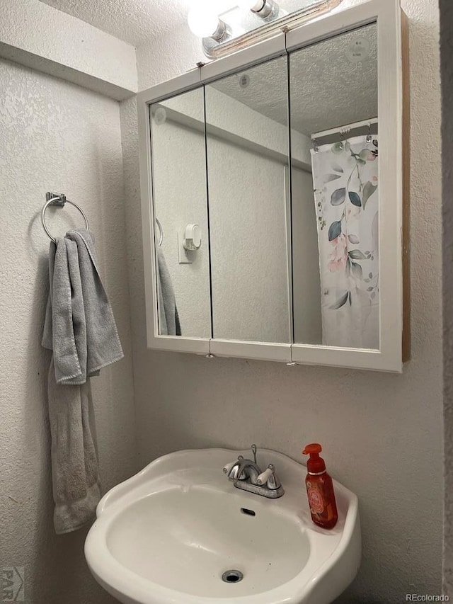 bathroom featuring sink and a textured ceiling