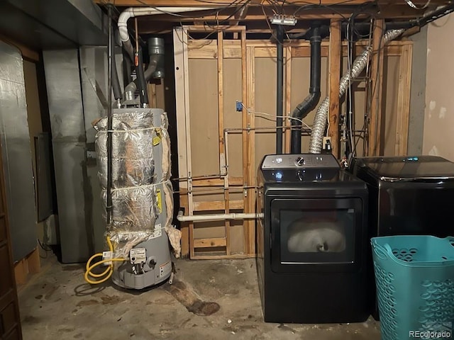 utility room with washer and dryer and water heater