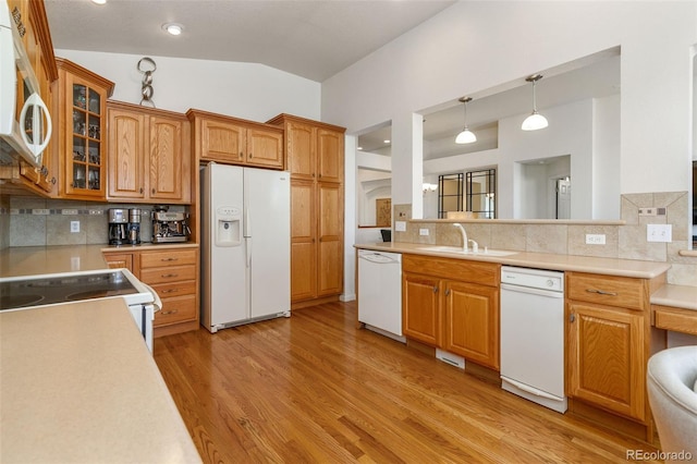 kitchen with tasteful backsplash, white appliances, vaulted ceiling, sink, and decorative light fixtures