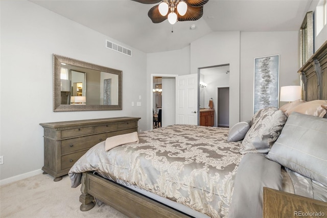 bedroom with ceiling fan, lofted ceiling, light carpet, and ensuite bath