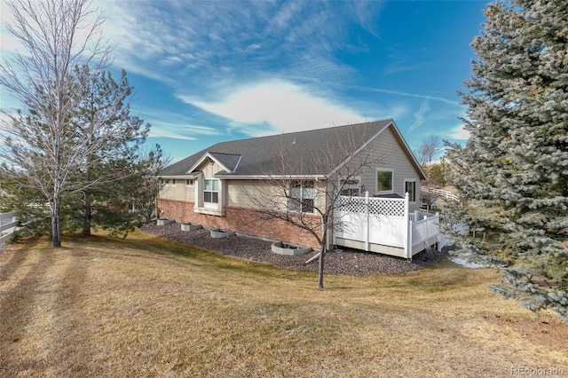 back of property featuring a deck and a yard