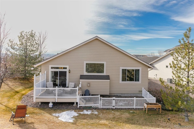 rear view of property with cooling unit, a yard, and a wooden deck