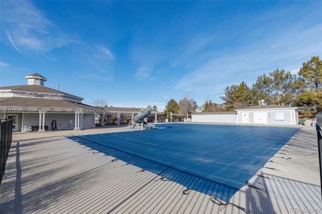 view of swimming pool with a water slide and a patio