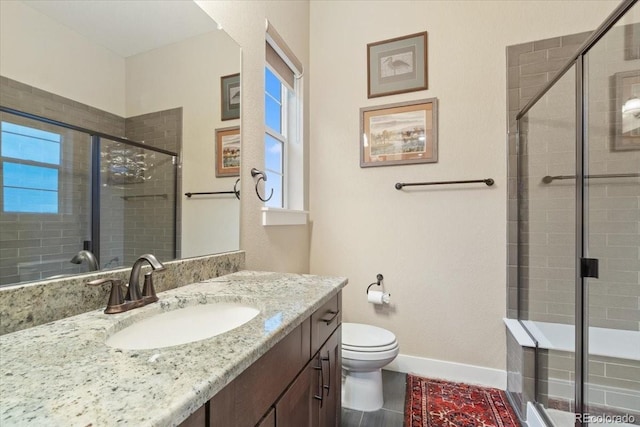 full bath with vanity, toilet, baseboards, and a stall shower