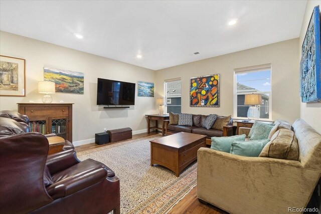 living room featuring wood finished floors, baseboards, and recessed lighting