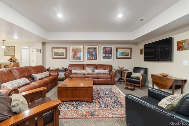 living room featuring a raised ceiling, carpet floors, visible vents, and recessed lighting