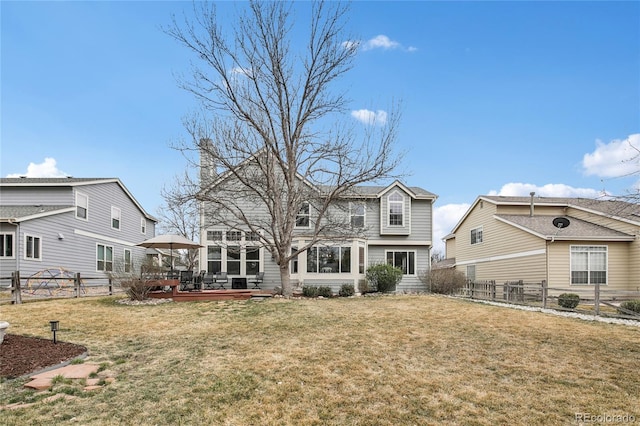 rear view of property featuring a fenced backyard, a lawn, and a wooden deck