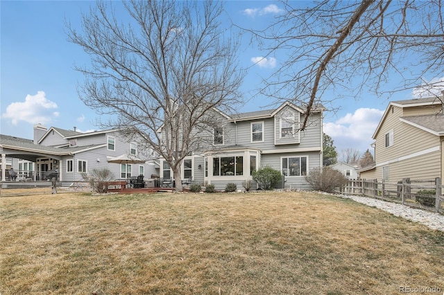back of house featuring a fenced backyard, a lawn, and a deck