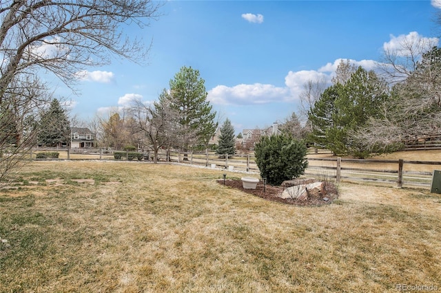view of yard with fence and a rural view