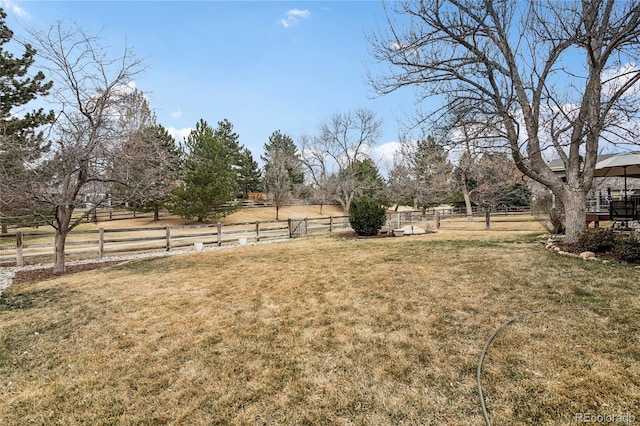 view of yard with fence and a rural view