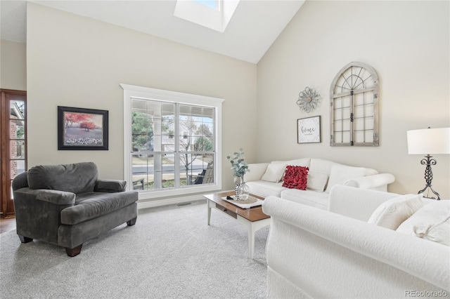 carpeted living room featuring high vaulted ceiling, visible vents, and a skylight