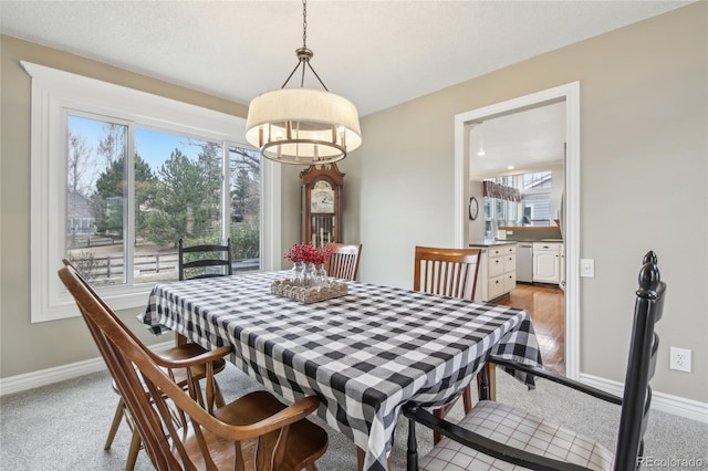 dining space featuring an inviting chandelier and baseboards