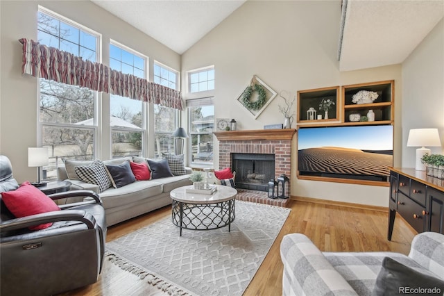 living area featuring a brick fireplace, high vaulted ceiling, baseboards, and wood finished floors